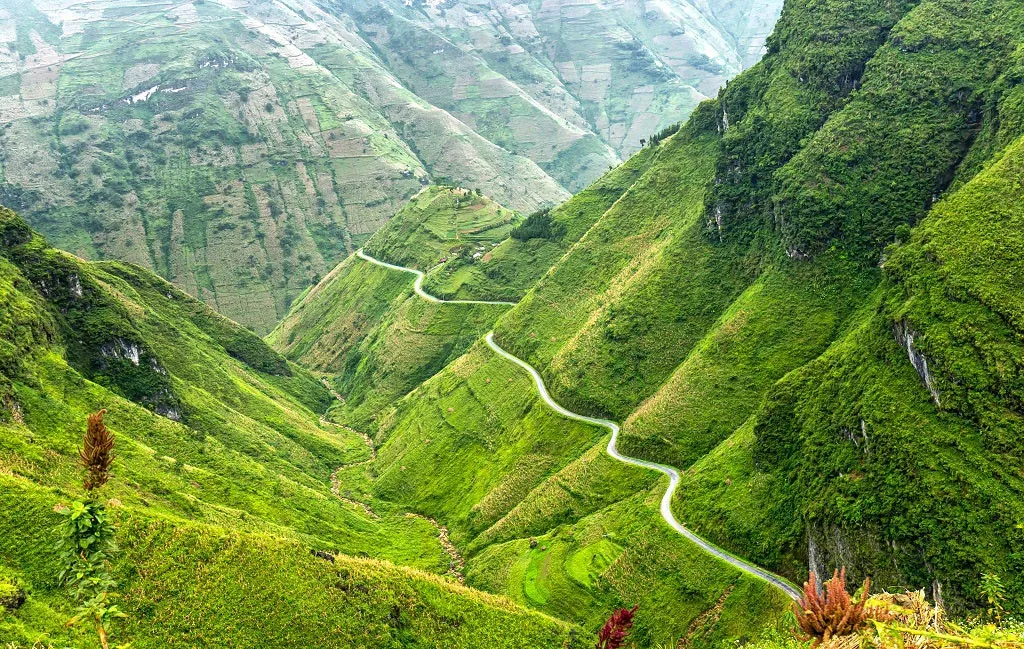 Motorbike riders crossing Ma Pi Leng Pass during autumn on the Ha Giang Loop